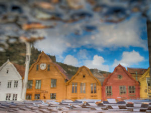 The historic row of houses at the harbor, Tyske Brygge in Bergen, Norway, is reflected in a puddle The historic row of houses at the harbor, Tyske Brygge in Bergen, Norway, is reflected in a puddle